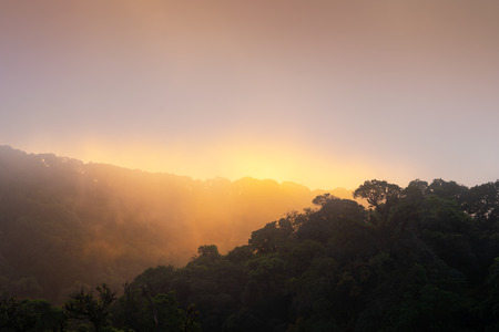 Sunrise from the top of mountain over the clouds, The sun goes up through the cloudy cloud at the top of the hill, the concept of natural care.の写真素材