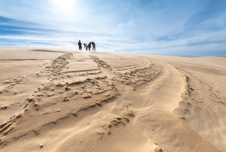 Unidentified tourists are traveling white sand dune desert at Mui Ne, Vietnamの写真素材