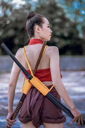 Asian woman warrior in Ayutthaya costume holding sword fight. Warrior woman of soldier of Bang...