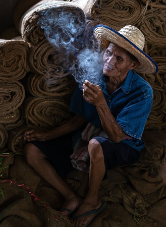 Old man smoking cigarette and the smoke released from the mouthのeditorial素材