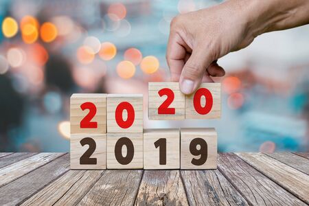 New Year concept from 2019 to 2020, Hand holds cube and changes wooden cubes to Year 2020.の写真素材
