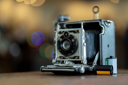 Retro film photo camera isolated on blurred background at light bokeh.の写真素材