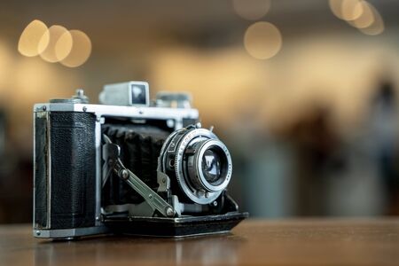 Retro film photo camera isolated on blurred background at light bokeh.の写真素材