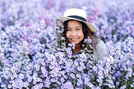 Portrait of teenage girl in a garden of flowers, Young happy asian girl in Margaret Aster flowers field in garden at Chiang Mai, Thailandの写真素材