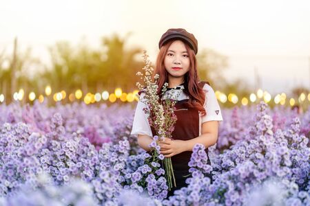 Portrait of teenage girl in a garden of flowers, Young happy asian girl in Margaret Aster flowers field in garden at Chiang Mai, Thailandの写真素材