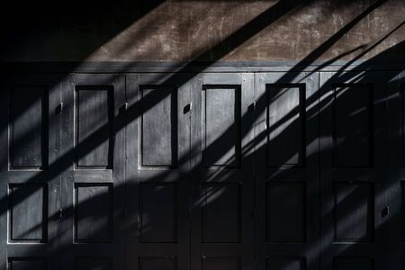 Black wooden vintage door and sun light shining for decorativeの写真素材