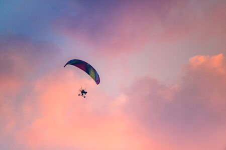 Colorful Paraglider flying against the twilight sky, sunset skyの写真素材