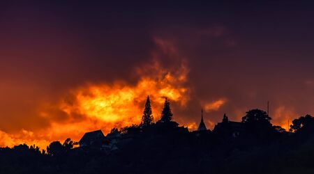 Beautiful sunset and orange sky, red clouds outdoor with the silhouetted Was Phra That Doi Suthep Temple, Important landmarks of Chiang Mai in Thailand.の写真素材
