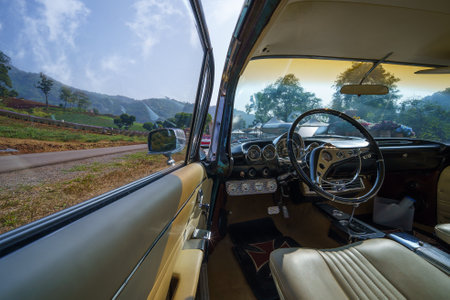 Chiang Mai, Thailand - January 22, 2021: Image in side of the old sports car scene front flower garden with mountain in the back.のeditorial素材