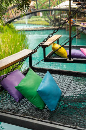 Comfortable colorful pillows lay on rope netting in garden for resting and relaxation.の写真素材