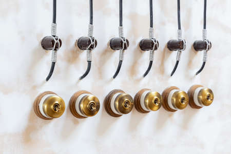 Retro style brass power switches on white wall. Brass vintage switch on interior wall.