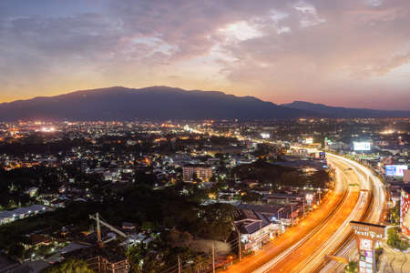 Chiang Mai, Thailand - December 17, 2021: Aerial high angle sunset cityscape and the light trails on...