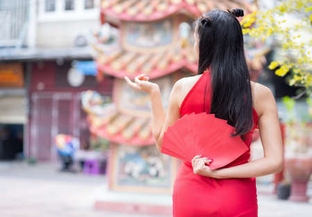 Asian woman holding red envelope with lucky money in Chinese New Yearの写真素材