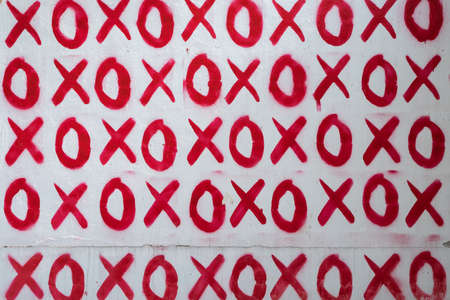 Red hand written doodle XO XO on white wall background, Hugs and kisses pattern. Love relationship in Valentines Dayの写真素材