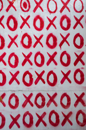 Red hand written doodle XO XO on white wall background, Hugs and kisses pattern. Love relationship in Valentines Dayの写真素材