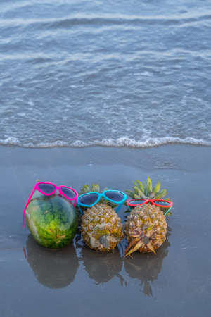 Fresh pineapple and watermelon on the sandy tropical beach with blue sky. Leisure in summer and...