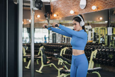 Muscular fit woman exercising. Fitness woman doing exercise, athletic girl workout in gym. Concept of healthy lifestyleの写真素材
