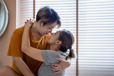 Happy LGBT gay lesbian couple looking together smile and embracing together in the bed room. lesbian...