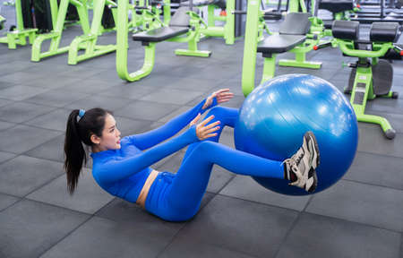 young women working out in the fitness. Fit girl training fitness ball in gym. Pilates workouts.の写真素材