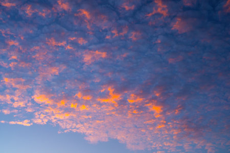 Stunning orange altocumulus clouds at sunset / sunrise. Amazing colorful sky.  Orange clouds on blue...