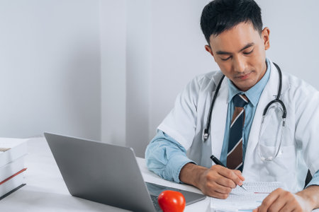 Doctor fills in data taking into account patient's analyzes. Filling out patient medical history, personal data. Diagnosed diseases blood vessels, heart.の写真素材