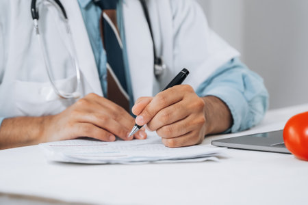 Doctor fills in data taking into account patient's analyzes. Filling out patient medical history, personal data. Diagnosed diseases blood vessels, heart.の写真素材
