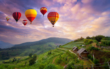 Colorful hot air balloons flying over mountain in sunrise at Khun Pae, Chiang Mai, Thailand.の写真素材
