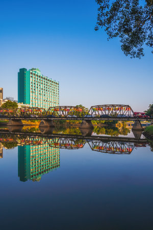 CHIANG MAI, THAILAND - NOVEMBER 8, 2022 : Reflection of Iron Bridge and colorful light lantern in sunrise. Loi Krathong or Yi Peng Festival in Chiang Mai, Thailandのeditorial素材