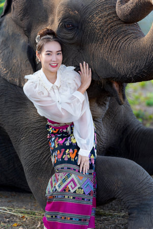 Beautiful girl sitting together with her best friend elephant at Lampang Province, Thailandの写真素材