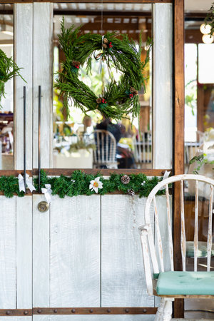 Christmas wreath hanging on the front door. Christmas decorations in front of the door. House decorated for Christmas outside.  Winter christmas background.の写真素材