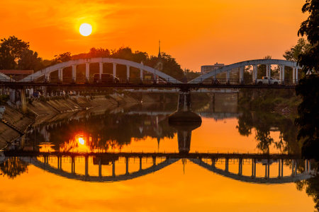 Lampang white bridge across Wang river called "Ratsadaphisek Bridge" in sunset, sunrise and reflection, It is regarded as one of the landmarks of Lampang Province, Thailand.の写真素材