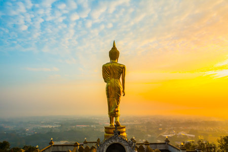 Golden Buddha standing with sea of fog and golden light sunrise in the early morning at Wat Phra That Khao Noi Temple, Nan province, Thailand.の写真素材