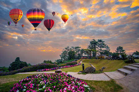 Cumulus clouds and golden sunlight on mountain with hot air balloons on morning at Thailand. Huai Nam Dang National Park, Chiang Mai in Thailand. Colorful hot air balloons flying over mountainの写真素材
