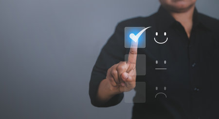 Customer service and Satisfaction concept ,Business people are touching the virtual screen on the happy Smiley face icon to show the satisfaction in service. feedback, rating, ranking, survey,choosingの写真素材