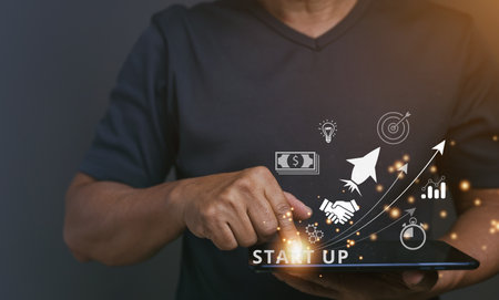 Startup concept with icon business and network connection on modern virtual interface from digital tablet. man touching on tablet. online business, e-comers, online marketing, small business.の写真素材