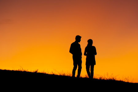 Silhouette of a couple in love at sunset background. Hadubai view point Ban Lao Wu, Wiang Haeng, Chiang Mai Copy space for use. Silhouette of lover on hill in sunsetの写真素材
