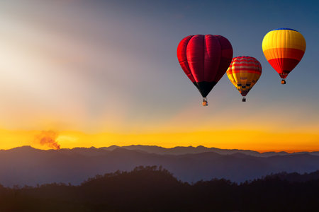 Colorful hot air balloon is flying at sunrise and sunset, hot air balloon Landscape at Sunrise. Travel, inspiration, success, dream, flight and freedom conceptの写真素材