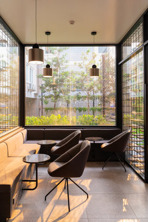 Inside room of the transparent glass wall in coffee shop. also can see the green garden outside the room through the glass wallの写真素材