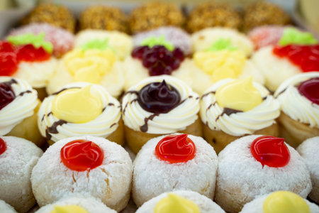 Round donuts stuffed with cream, chocolate and raspberry jam on the shelf in the delicious donut shop. copy spaceの写真素材