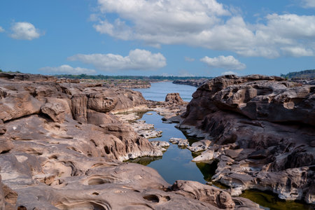 Stone scenery that is eroded by river. When water level of Mekong river down, beautiful shape of stones can be found. Taken at Sam Phan Bok, Ubon Ratchathani, Thailand. Shape stone face dogの素材 [FY310207989384]