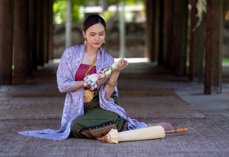 Beautiful Asian women wearing in Thai dress costume traditional according Thai culture and tradition at the ancient wooden temple Chiang Mai, Thailand.Portrait asian Model with smilingの写真素材