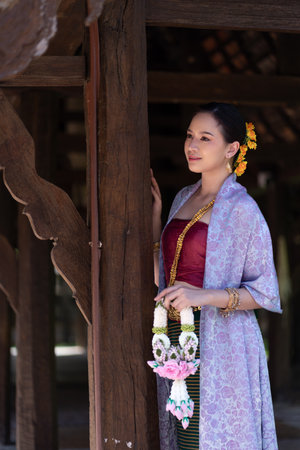 Beautiful Asian women wearing in Thai dress costume traditional according Thai culture and tradition at the ancient wooden temple Chiang Mai, Thailand.Portrait asian Model with smilingの写真素材