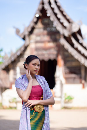 Beautiful Asian women wearing in Thai dress costume traditional according Thai culture and tradition at the ancient wooden temple Chiang Mai, Thailand.Portrait asian Model with smilingの写真素材
