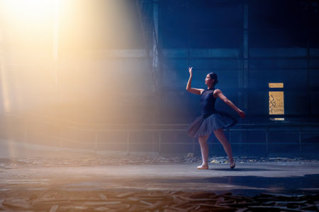 Ballet. Ballerina dancing on the dark floor. Young graceful woman ballet dancer demonstrating dancing skill. Beauty of classic ballet in Chiang Mai, Thailand - April 10, 2023のeditorial素材