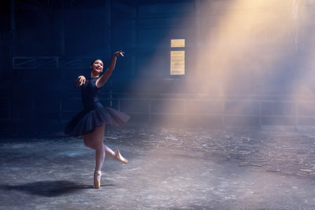Ballet. Ballerina dancing on the dark floor. Young graceful woman ballet dancer demonstrating dancing skill. Beauty of classic ballet in Chiang Mai, Thailand - April 10, 2023のeditorial素材