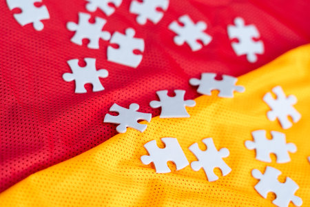 Jigsaw puzzle white color pieces on Colorful athletic Jersey texture, Sports jersey clothing fabric. Copy Space. Fabric texture with holes and white puzzle Jigsawの写真素材