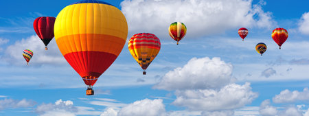 Hot Air Balloon Ride in blue sky white clouds background for wide banner of travel agency or adventure tour. Romance of ballooning in a good weather. Hot air balloons flies in blue sky. Copy spaceの写真素材