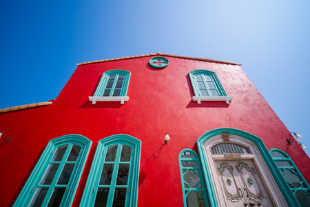 Red wall house and Green windows on the street. Red house with green door. Green window, door on a red wall of a modern house in Franceの写真素材