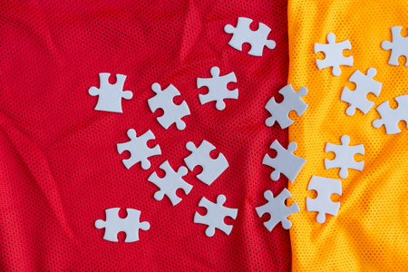 Jigsaw puzzle white color pieces on Colorful athletic Jersey texture, Sports jersey clothing fabric. Copy Space. Fabric texture with holes and white puzzle Jigsawの写真素材