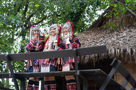 CHIANG MAI, THAILAND - AUGUST 26, 2023 : Akha women with traditional clothes and silver jewelry on wooden house in Akha tribe Villages. Young Asian lady Akha tribe.のeditorial素材